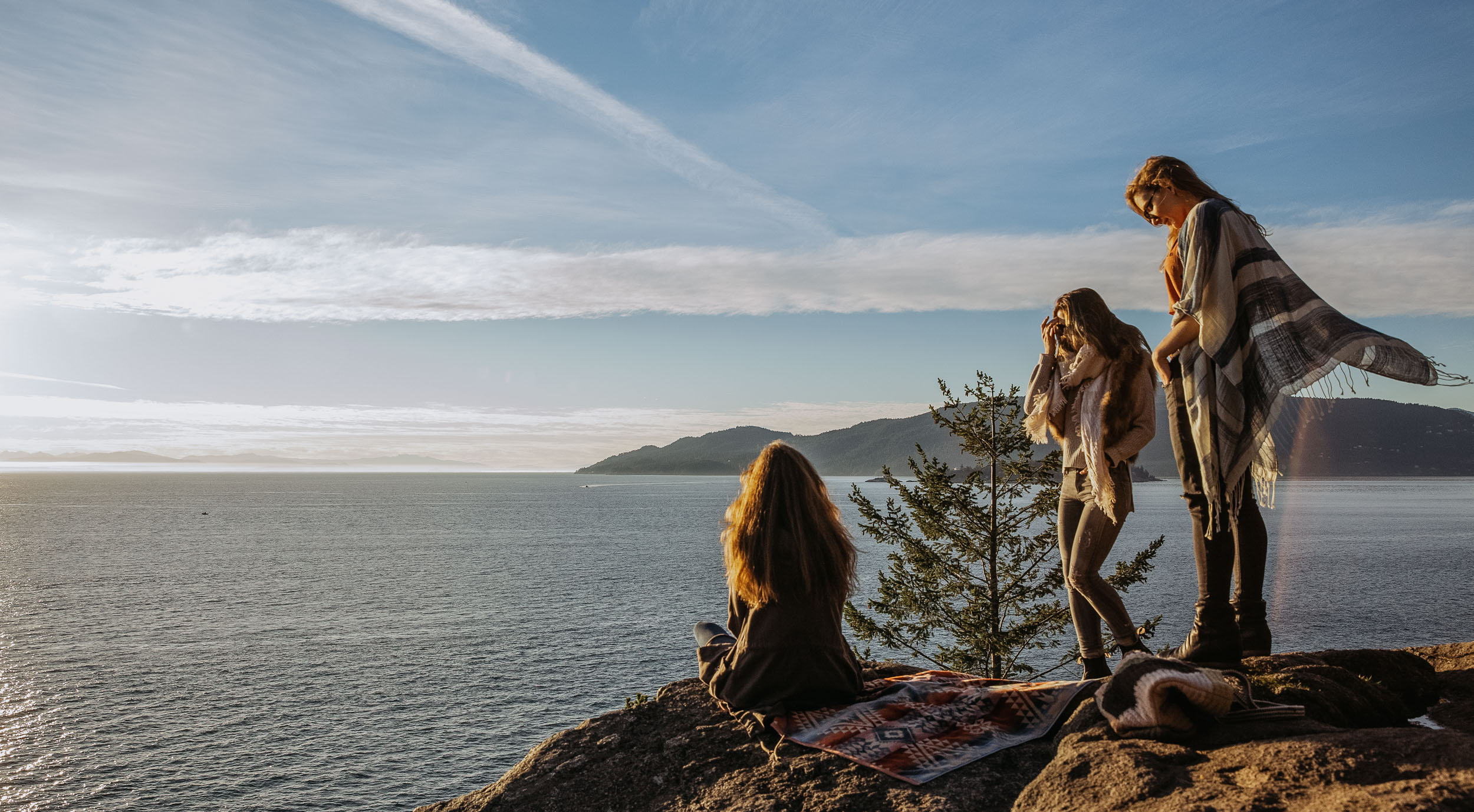 women on rocks near ocean 